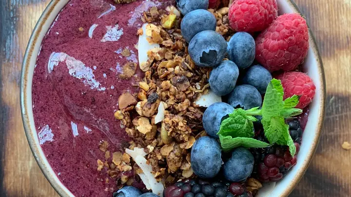 Tigela de açaí com granola, mirtilo e framboesa