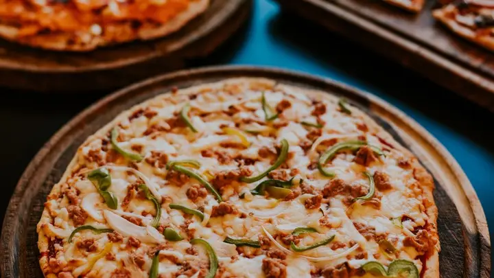 Pizzas recém-saídas do forno em tábuas de madeira